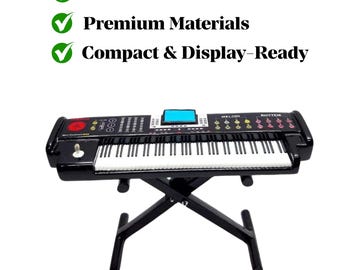 May include: A black miniature keyboard with white keys and a blue screen, mounted on a black X-shaped stand. The keyboard has the words "MELODI" and "RHYTHM" printed on it. The text "Handcrafted Precision", "Premium Materials", and "Compact & Display-Ready" is also visible.