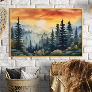 Puede incluir: Una pintura de acuarela enmarcada de una escena de bosque al atardecer. La obra presenta altos árboles de hoja perenne en tonos de azul y verde, con un cielo naranja y amarillo vibrante. La pintura está en un marco de madera marrón claro.