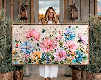Puede incluir: Una pieza de arte mural rectangular enmarcada que presenta una vibrante ilustración floral al estilo acuarela. La obra muestra una variedad de flores cosmos rosas, azules y amarillas, tallos verdes y pequeñas mariposas sobre un fondo claro y suave.