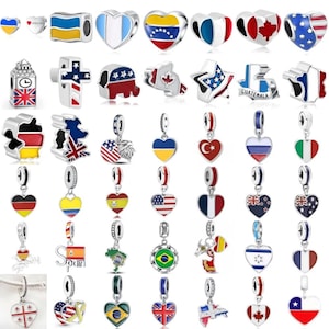 May include: A selection of silver charms displaying national flags and symbols. The charms include heart-shaped pendants, flag designs, and iconic landmarks. The charms are detailed with enamel in various colours, showcasing flags from around the world.