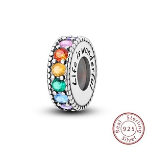 May include: A sterling silver charm with a rainbow of colorful gemstones. The charm is engraved with the words "Life is wonderful". The charm is a bead style and is suitable for bracelets and necklaces.