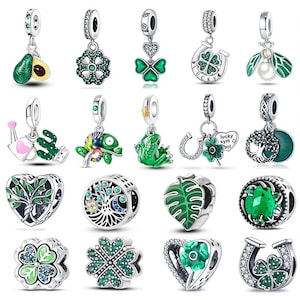 May include: A selection of silver charms with green detailing. Charms feature an avocado, four-leaf clovers, a horseshoe, a ladybug, a watering can, a cactus, a chameleon, a frog, a tree of life, and a leaf.