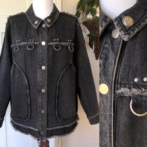 May include: Black denim jacket with silver hardware, distressed edges, and a frayed hem.