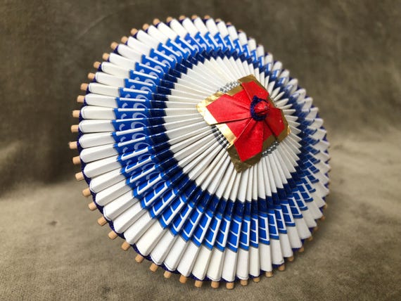 A genuine miniature Japanese wagasa parasol hand-folded from recycled paper — tramp art meets traditional craft in an impossibly tiny object.