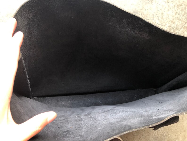 Puede incluir: El interior de una bolsa de cuero negra. La bolsa est&aacute; vac&iacute;a y el forro es de color gris oscuro.