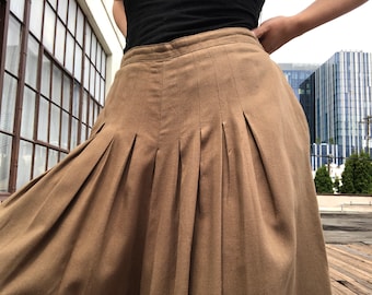 May include: A brown pleated skirt with a high waist and a flowing silhouette.