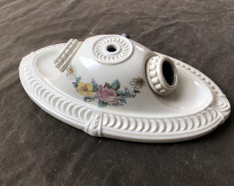 Peut inclure: Luminaire de plafond ovale en céramique blanc cassé avec des motifs floraux. Le luminaire a un bord décoratif et deux douilles. Le motif floral comprend des fleurs roses, jaunes et bleues. Conçu pour être monté au plafond.