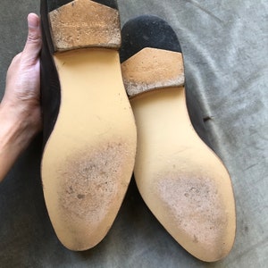 Puede incluir: Primer plano de las suelas de dos zapatos de cuero marr&oacute;n. Las suelas est&aacute;n hechas de cuero marr&oacute;n claro y tienen un patr&oacute;n texturizado. Los zapatos est&aacute;n hechos en Italia.