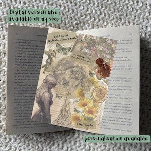 May include: A decorative bookmark featuring a collage of vintage illustrations, including a woman, butterflies, and sunflowers. The bookmark is placed on an open book with text visible. Text on the bookmark reads "Just A Girl And Her Emotional Support Kindle".