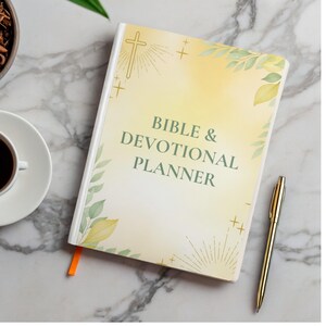 Op de afbeelding: Een Bijbel & Devotional Planner met een zachte gele en witte kaft, met de tekst "Bible & Devotional Planner" in het groen. De kaft is versierd met een kruis, zonnestralen en groene bladeren. Een gouden pen ligt naast de planner.