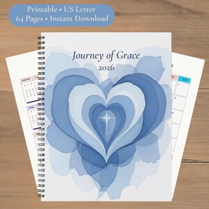 Op de afbeelding: Een spiraalgebonden planner met een blauw aquarel hartontwerp. De omslag luidt "Journey of Grace 2026." Extra tekst omvat "Printable • US Letter," "64 Pages • Instant Download." Kalenderpagina's zijn zichtbaar.
