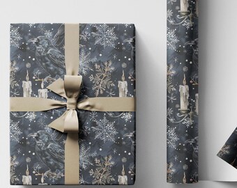 May include: A wrapped gift box and a roll of wrapping paper. The paper has a dark blue background with a pattern of snowflakes, candles, and gold accents. A gold ribbon and bow adorn the gift box.