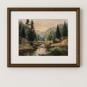 May include: A framed art print showcasing a tranquil mountain landscape. The image portrays a stream winding through a valley, surrounded by verdant trees and distant mountains beneath a warm, golden sky. The print is set within a dark brown, decorative frame.