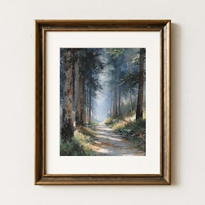 May include: A framed watercolor painting of a forest path. Tall trees line the path, with sunlight filtering through the canopy. The frame is a dark, ornate gold color, and the painting is set behind a white mat.