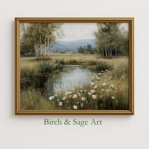 May include: A framed landscape painting with a gold-colored frame. The artwork depicts a serene pond scene with trees, wildflowers, and distant hills. The text "Birch & Sage Art" is at the bottom of the frame.