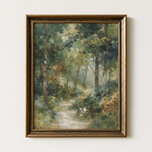 Può includere: Una stampa d'arte incorniciata raffigurante una scena forestale impressionista con un sentiero sterrato tortuoso circondato da fitti alberi verdi, fogliame e luce soffusa. L'opera è racchiusa in una cornice rettangolare color bronzo scuro.