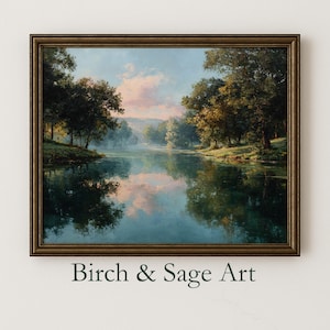 May include: A framed landscape painting depicts a serene lake scene with trees lining the banks. The water reflects the sky and surrounding foliage. The artwork has a vintage aesthetic, with a warm color palette. The text "Birch & Sage Art" is at the bottom.
