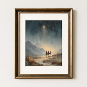 May include: A framed watercolor print depicts three figures on camels following a bright star in the night sky. The artwork features a landscape with mountains and a muted color palette of blues, browns, and gold.