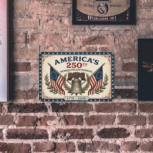May include: A rectangular metal sign commemorating America's 250th anniversary. The sign features the text "America's 250th Semiquincentennial" with the years 1776-2026. It includes illustrations of the Liberty Bell and American flags.