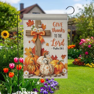 Peut inclure: Un drapeau de jardin avec une croix en bois, un nœud orange, des feuilles d'automne et des citrouilles. Le drapeau affiche le texte "GIVE thanks TO THE Lord - Psalm 136:1". Le design est sur un fond beige, parfait pour la décoration automnale.