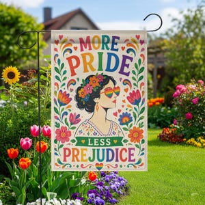 May include: A rectangular garden flag featuring a colorful illustration of a person with dark hair adorned with flowers, wearing heart-shaped rainbow sunglasses. The text reads MORE PRIDE and LESS PREJUDICE, surrounded by vibrant floral motifs.