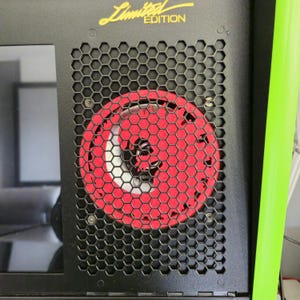 Könnte beinhalten: Schwarzes Computergehäuse mit einem wabenförmigen Gitter über einem roten Lüfter. Die Worte "Limited Edition" stehen in goldfarbenen Buchstaben oben. Ein grüner Akzent verläuft an der Seite des Gehäuses.