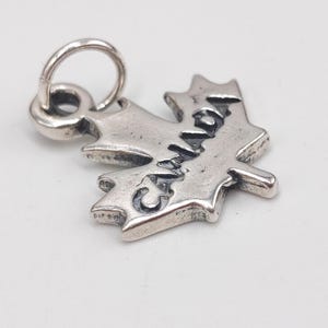 Op de afbeelding: Een witte keramische mok met een zwarte handgreep en de tekst "But First, Coffee" in een vetgedrukte, zwarte letter. De mok staat tegen een neutrale achtergrond, wat het eenvoudige ontwerp benadrukt.