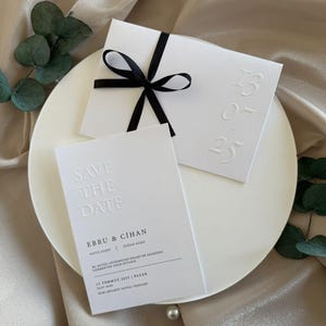 Luxury Wedding Invitation – White Embossed Date Card with Bold Black Ribbon and Elegant Minimal Design