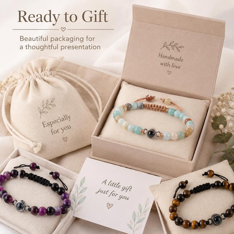 May include: An assortment of beaded bracelets in gift boxes and a drawstring bag. The bracelets feature various colored beads, including blue, purple, and brown. The packaging includes the text "Ready to Gift" and "Handmade with love."