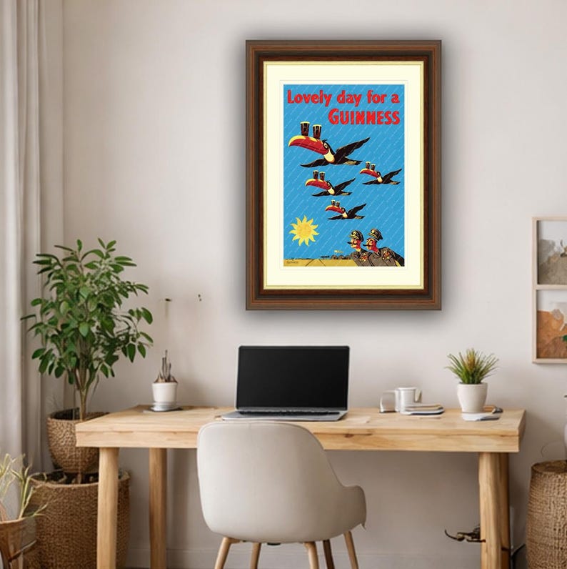 May include: Framed vintage Guinness advertisement. The print features toucans carrying pints of Guinness, with the text "Lovely day for a Guinness" in red. The background is blue with a yellow sun.