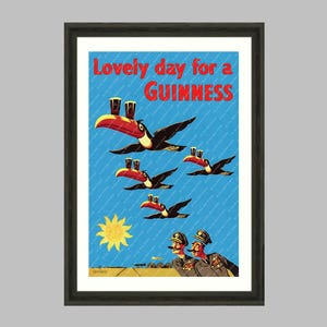 May include: Framed wall art print featuring a vintage Guinness advertisement. The image shows toucans carrying pints of Guinness, with the text "Lovely day for a Guinness." The sun and two men in uniform are also depicted.