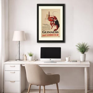 May include: Framed vintage advertisement for Guinness and Lobster. The artwork features a red lobster holding a bottle of Guinness. The text reads "Guinness and Lobster" in bold letters. The poster is framed in black.