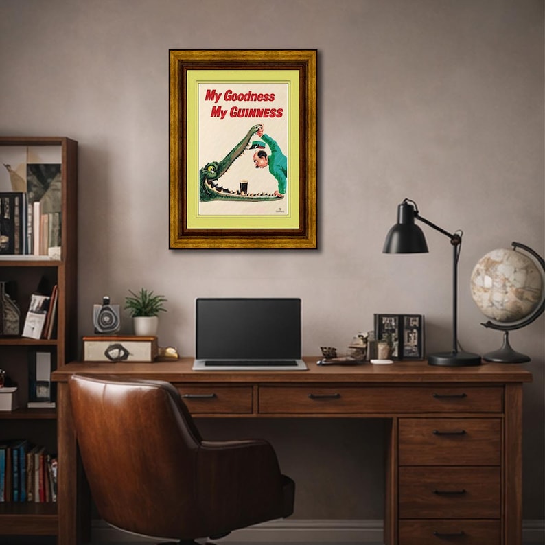 May include: A framed vintage Guinness advertisement poster. The poster features the text "My Goodness My Guinness" and an illustration of a man pouring stout into a crocodile's mouth. The poster is in a gold frame and hangs on a wall.