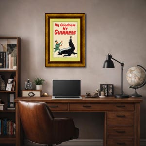 May include: A framed vintage Guinness advertisement featuring a cartoon of a seal balancing a pint of Guinness on its nose. The text "My Goodness My Guinness" is in red and white.