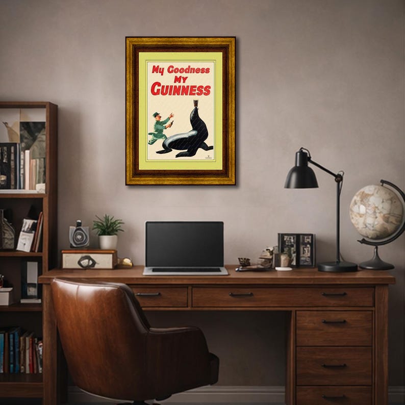 May include: A framed vintage Guinness advertisement featuring a cartoon of a seal balancing a pint of Guinness on its nose. The text "My Goodness My Guinness" is in red and white.