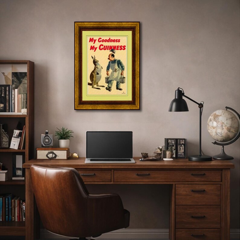 K&ouml;nnte beinhalten: Gerahmte Vintage-Werbung mit einem K&auml;nguru und einem Mann in einer Arbeitssch&uuml;rze, der Werkzeugk&auml;sten h&auml;lt. Der Text "My Goodness My Guinness" ist rot auf gelbem Hintergrund dargestellt. Der Rahmen ist dunkelbraun.