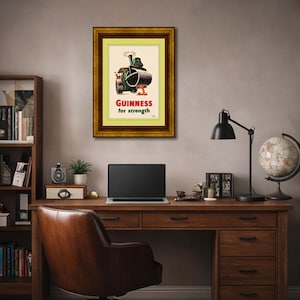 Puede incluir: Anuncio vintage enmarcado de Guinness. La obra de arte presenta una ilustraci&oacute;n caprichosa de un veh&iacute;culo de la marca Guinness. El texto "Guinness for strength" se muestra en rojo. El marco es de color madera oscura.