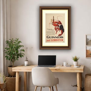 May include: Framed vintage advertisement for Guinness and Lobster. The artwork features a red lobster holding a pint of Guinness. The text reads "Guinness and Lobster" in a bold font, with additional text below.