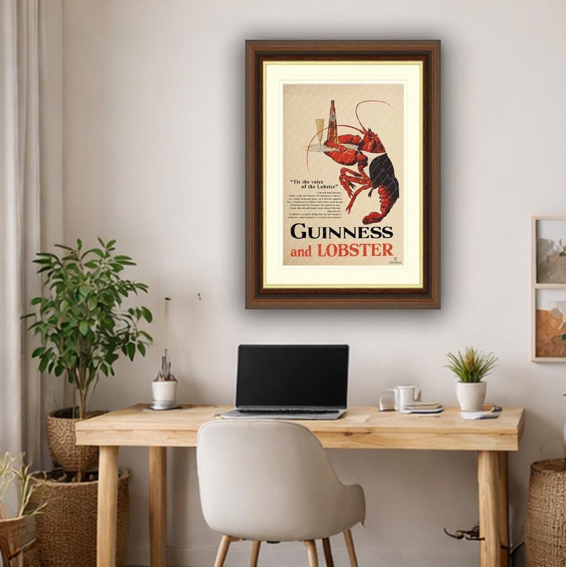 May include: Framed vintage advertisement for Guinness and Lobster. The artwork features a red lobster holding a pint of Guinness. The text reads "Guinness and Lobster" in a bold font, with additional text below.