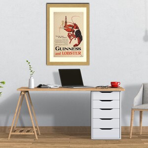 May include: A framed vintage advertisement for Guinness and Lobster. The artwork features a red and black lobster holding a bottle of Guinness. The text "Guinness and Lobster" is prominently displayed. The frame is gold-colored.