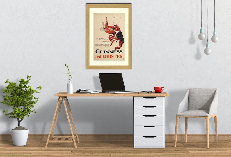 May include: A framed vintage advertisement for Guinness and Lobster. The artwork features a red and black lobster holding a bottle of Guinness. The text "Guinness and Lobster" is prominently displayed. The frame is gold-colored.