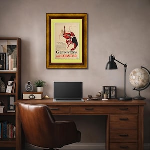 May include: A framed vintage advertisement for Guinness and Lobster. The artwork features a red lobster holding a bottle of Guinness. The frame is gold with a yellow mat. The text reads "Guinness and Lobster."