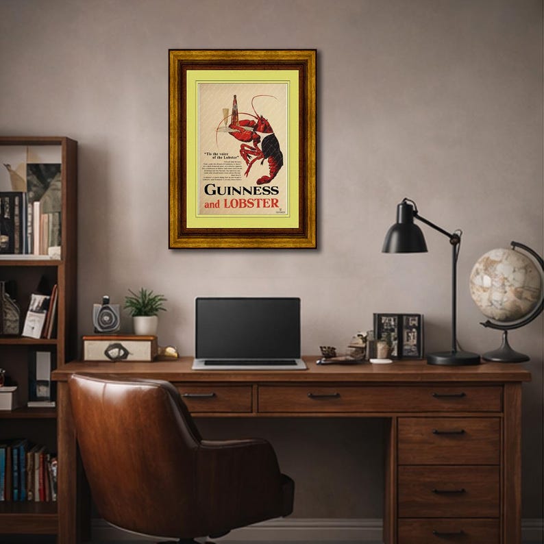 May include: A framed vintage advertisement for Guinness and Lobster. The artwork features a red lobster holding a bottle of Guinness. The frame is gold with a yellow mat. The text reads "Guinness and Lobster."