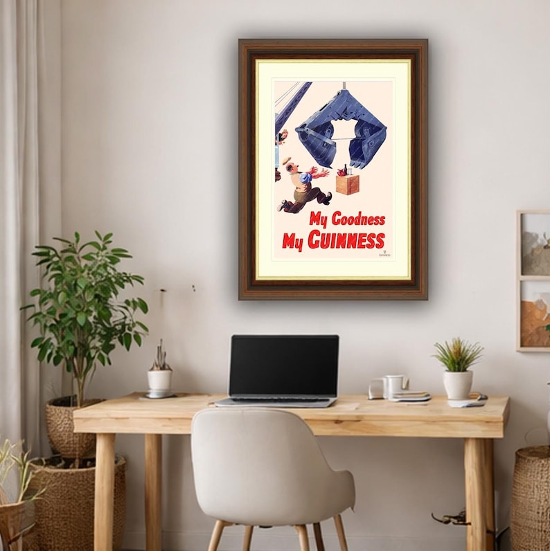 Pode incluir: An&uacute;ncio vintage emoldurado para Guinness. A obra de arte retrata um homem fugindo de uma grande estrutura azul em forma de garra. O texto "My Goodness My Guinness" est&aacute; em vermelho. A moldura &eacute; marrom.