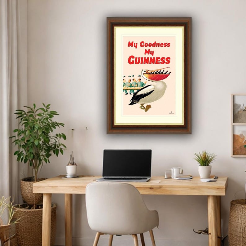 May include: Framed vintage advertisement print featuring a pelican with a large red pouch, holding a row of people. The text "My Goodness My Guinness" is in red. The print is in a brown frame.