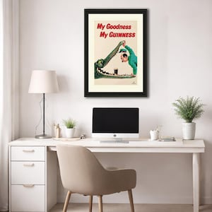 May include: Framed vintage Guinness advert. A man in green pours a pint of Guinness into an alligator's mouth. The text "My Goodness My Guinness" is in red. The artwork is framed in black, a classic piece of advertising.