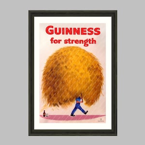 May include: Framed vintage Guinness advertisement. The poster features a man in blue carrying a large bundle of hay, with the text "Guinness for strength" in red. A bottle of Guinness is on the ground. The Wall Art Parlour Collection.
