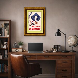 Pode incluir: An&uacute;ncio vintage emoldurado da Guinness. A obra de arte apresenta um homem e uma caixa caindo de um paraquedas azul. O texto "My Goodness My Guinness" &eacute; exibido em vermelho e verde. A moldura &eacute; dourada.