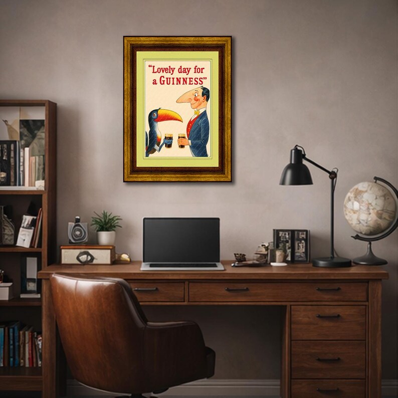 Puede incluir: Anuncio vintage enmarcado de Guinness con un tuc&aacute;n y un hombre sosteniendo pintas de Guinness. El texto dice "Lovely day for a Guinness" en letras rojas. El marco es de color madera oscura.