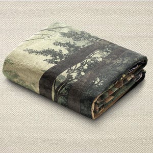 May include: Folded blanket featuring a forest scene with trees in shades of green, brown, and black. The blanket is folded neatly, showcasing the detailed print of the forest landscape. The edges are finished with a contrasting border.